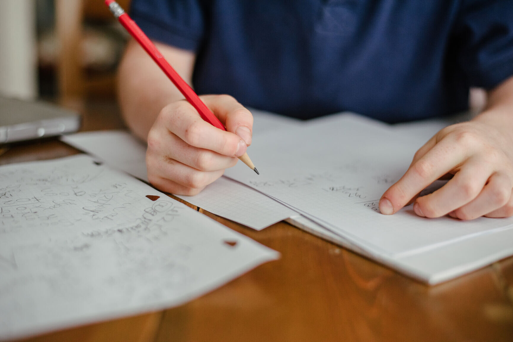 Close up of a boy's hands writing his homework